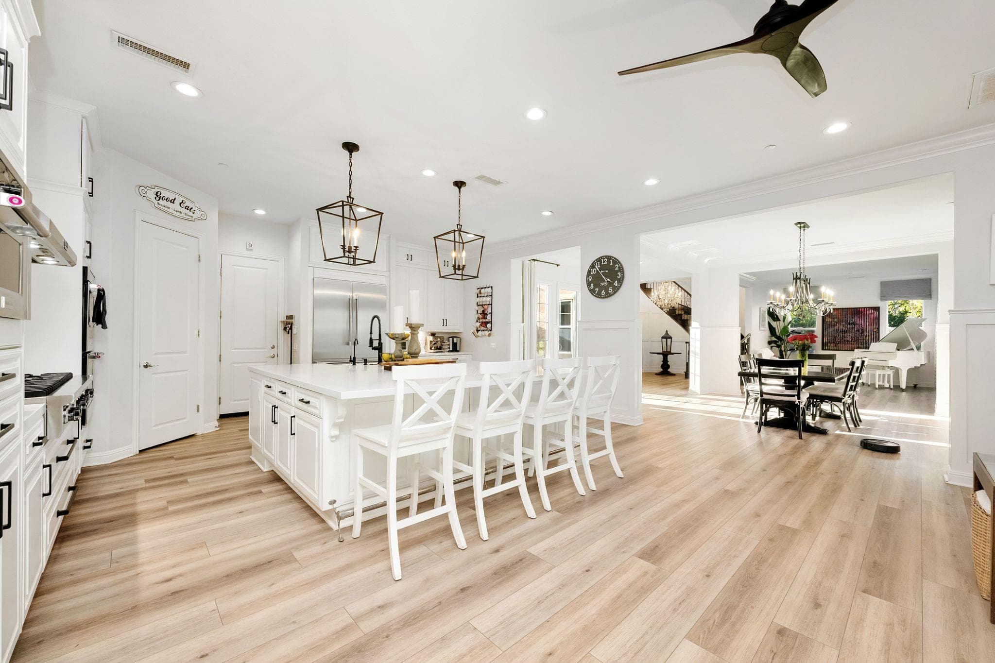 A bright residential kitchen with island and dining area